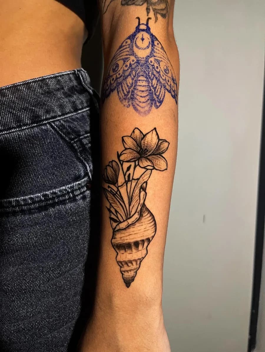 Mariposa e concha em blackwork no antebraço